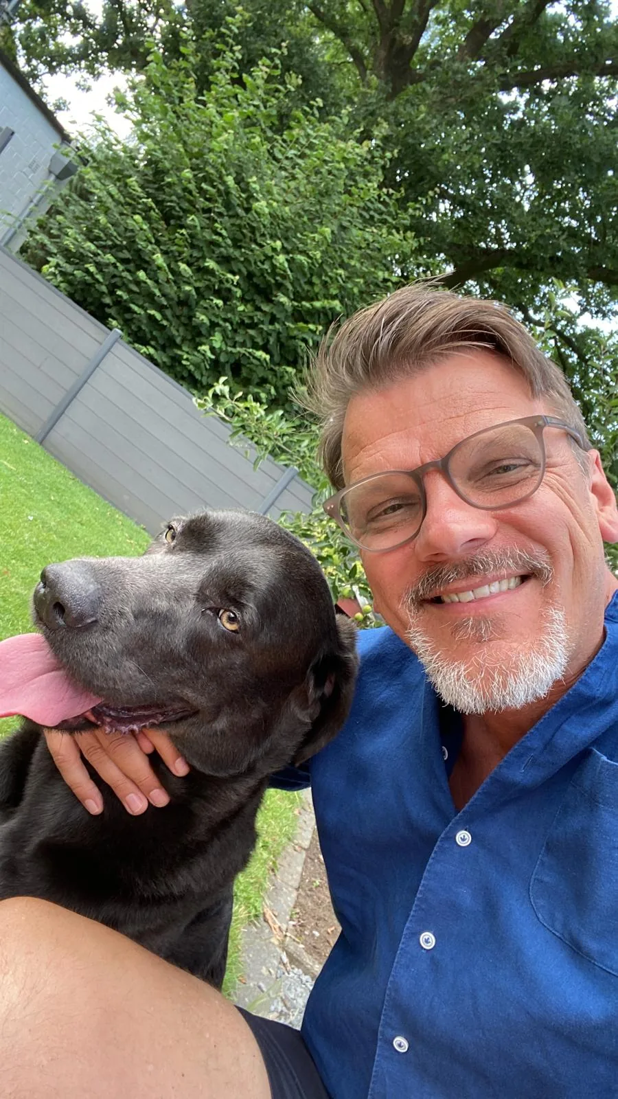 Person mit Hund im Garten – privates Foto, Sommer 2026